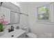 Bright bathroom featuring modern sink, toilet, and window with natural light at 7219 Spring Morning Ln, Charlotte, NC 28227