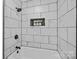 Modern bathroom with marble-look tiles, black fixtures, and decorative inset shelving at 7219 Spring Morning Ln, Charlotte, NC 28227