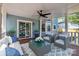 Inviting covered deck with comfortable seating, ceiling fan, and sliding door access to the home's interior at 7219 Spring Morning Ln, Charlotte, NC 28227