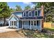 Inviting two-story home with neat landscaping and a cozy covered front porch and white railing at 7219 Spring Morning Ln, Charlotte, NC 28227