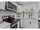 Modern kitchen featuring stainless steel appliances, white cabinets and countertops, and black hardware at 7219 Spring Morning Ln, Charlotte, NC 28227