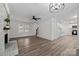 Spacious living room with wood-look floors, fireplace, modern lighting, and open layout to the kitchen at 7219 Spring Morning Ln, Charlotte, NC 28227
