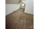 Finished attic space with carpeted floors and a small window at 743 S College Ave, Newton, NC 28658
