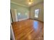View of a bedroom featuring hardwood floors, light colored walls and a large window at 743 S College Ave, Newton, NC 28658