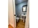 Powder room featuring a pedestal sink, toilet, and hardwood floors at 743 S College Ave, Newton, NC 28658