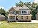 Stunning two-story brick home with a covered front porch and lush green lawn at 7717 Nautical View Dr, Denver, NC 28037