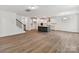 Open concept living room and kitchen area with hardwood floors and modern lighting fixtures at 7717 Nautical View Dr, Denver, NC 28037