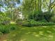 Beautiful backyard with well-maintained lawn, garden beds, and a wooden fence for added privacy at 827 Museum Dr, Charlotte, NC 28207
