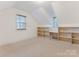 Bright bedroom with sloped ceiling features built-in shelving and desk at 827 Museum Dr, Charlotte, NC 28207