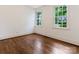 Empty bedroom features gleaming hardwood floors and lots of light from the double windows at 827 Museum Dr, Charlotte, NC 28207