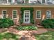 Close up of a brick home's front door, accented with greenery and black iron railings at 827 Museum Dr, Charlotte, NC 28207