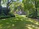 Charming home surrounded by mature trees and a lush green lawn with beautiful landscaping at 827 Museum Dr, Charlotte, NC 28207