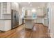 White kitchen with stainless appliances, island and hardwood flooring at 827 Museum Dr, Charlotte, NC 28207