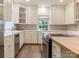 Bright kitchen with white cabinets, stainless appliances, and a butcher block island with cooktop at 827 Museum Dr, Charlotte, NC 28207