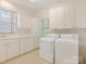 Light and bright laundry room with washer, dryer, sink and lots of cabinet storage at 827 Museum Dr, Charlotte, NC 28207