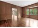 Large room with rich wood paneling, hardwood floors and bright bay window at 827 Museum Dr, Charlotte, NC 28207