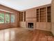 Living room with rich wood paneling, fireplace and custom built in shelving at 827 Museum Dr, Charlotte, NC 28207
