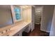 Well-lit bathroom with a double sink vanity, mirror, and open closet at 9424 Whitethorn Dr, Charlotte, NC 28277