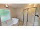 Cozy bathroom includes a tub, shower, and warm lighting at 9424 Whitethorn Dr, Charlotte, NC 28277