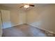 Neutral bedroom with carpet, ceiling fan, and a double-door closet, offering a clean and adaptable space at 9424 Whitethorn Dr, Charlotte, NC 28277