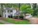 Two-story home with attached garage, manicured lawn, and classic architectural features, nestled among mature trees at 9424 Whitethorn Dr, Charlotte, NC 28277