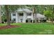 Classic colonial-style home with a manicured lawn, mature trees, and symmetrical facade at 9424 Whitethorn Dr, Charlotte, NC 28277
