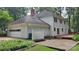 Back exterior showing a two-car garage, brick patio, and wooden deck - perfect for outdoor relaxation at 9424 Whitethorn Dr, Charlotte, NC 28277