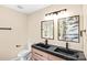 Modern bathroom with dual sinks, a dark countertop, wood-style cabinetry, and decorative mirrors at 953 Milkwood Ln, Monroe, NC 28110