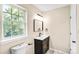 Bathroom showcasing a modern vanity, black mirror, and window with natural light at 953 Milkwood Ln, Monroe, NC 28110