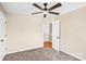 Neutral bedroom featuring carpet floors, ceiling fan, and an open doorway at 953 Milkwood Ln, Monroe, NC 28110