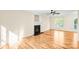 Living room with hardwood floors, a cozy fireplace, ceiling fan, and natural light at 953 Milkwood Ln, Monroe, NC 28110