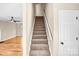 Carpeted staircase leading to the upper level with a white door at the base of the stairs at 953 Milkwood Ln, Monroe, NC 28110