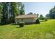 Back exterior shot showing well-kept home with green lawn, surrounded by tall trees at 110 Leeper Ave, Belmont, NC 28012