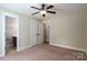 Neutral bedroom featuring carpet, a ceiling fan, and bathroom and closet entrances at 110 Leeper Ave, Belmont, NC 28012
