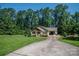 Well-maintained property featuring a front porch, attached carport, and a spacious lawn surrounded by trees at 110 Leeper Ave, Belmont, NC 28012