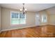 Spacious living room featuring hardwood floors, natural light, and a view of the front entrance and chandelier lighting at 110 Leeper Ave, Belmont, NC 28012