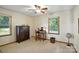 Cozy bedroom featuring a ceiling fan, wood desk and hutch, and bright natural light from two windows at 1119 Palmyra Dr, Fort Mill, SC 29708