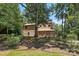 Exterior showcasing natural landscaping and a rustic wood facade shaded by mature trees on a sunny day at 1119 Palmyra Dr, Fort Mill, SC 29708