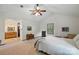 Spacious main bedroom featuring a ceiling fan, multiple dressers, and an ensuite bathroom at 1119 Palmyra Dr, Fort Mill, SC 29708
