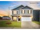 Charming two-story home featuring stone accents, a two-car garage, and a well-manicured lawn at 115 Rustling Waters Dr, Mooresville, NC 28117