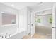 Bathroom view into bedroom featuring large window, soaking tub and doorway at 120 Carolinian Dr, Statesville, NC 28677