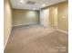 Finished basement space with neutral carpeting, ample lighting, and convenient access to other rooms at 1228 N Dobys Bridge Rd, Fort Mill, SC 29715