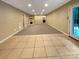 Spacious basement featuring tile and carpet flooring, recessed lighting, and a convenient walk-out door at 1228 N Dobys Bridge Rd, Fort Mill, SC 29715