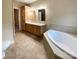 Primary bathroom featuring double sink vanity, soaking tub, and tile flooring at 1228 N Dobys Bridge Rd, Fort Mill, SC 29715