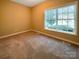 Carpeted bedroom with neutral walls and a bright window offering natural light and ventilation at 1228 N Dobys Bridge Rd, Fort Mill, SC 29715