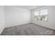 Bright bedroom with large window and neutral carpet flooring at 12548 Gotland Rd # 327, Midland, NC 28107