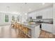 Modern kitchen with white cabinets, gray countertops, stainless steel appliances, and a large center island at 13920 Winmau Ln, Huntersville, NC 28078