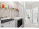 Modern laundry room with white washer and dryer, utility shelving, and ample space at 13920 Winmau Ln, Huntersville, NC 28078
