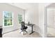 Bright office space featuring a modern desk, ergonomic chair, and natural light from two windows at 13920 Winmau Ln, Huntersville, NC 28078