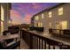 A wooden patio with furniture overlooking the neighborhood against a vibrant sunset sky at 13920 Winmau Ln, Huntersville, NC 28078